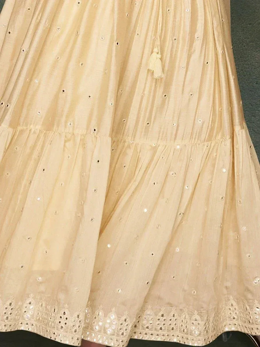 Beige ethnic gown with eyelet embroidery and tassel detail, perfect for Indian occasions