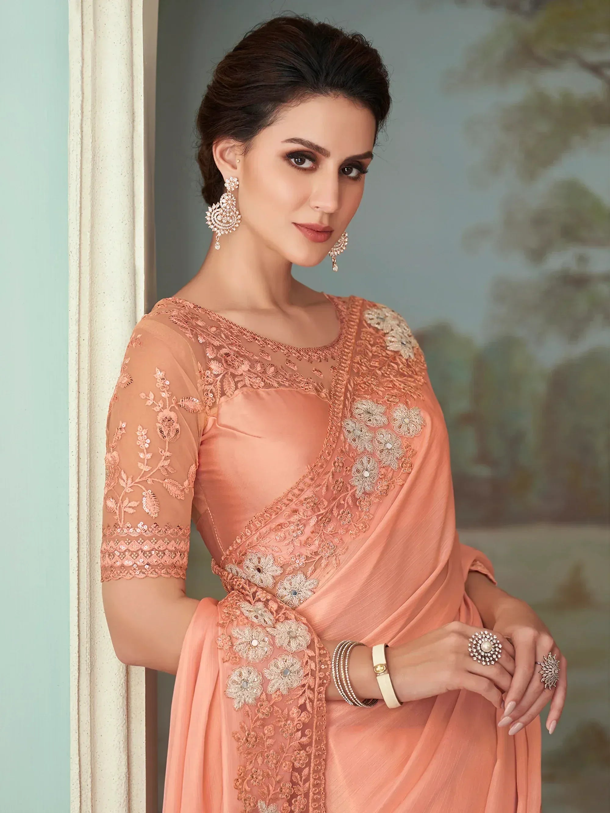 Elegant peach saree with floral embroidery and sheer sleeves, perfect for Indian ethnic occasions.