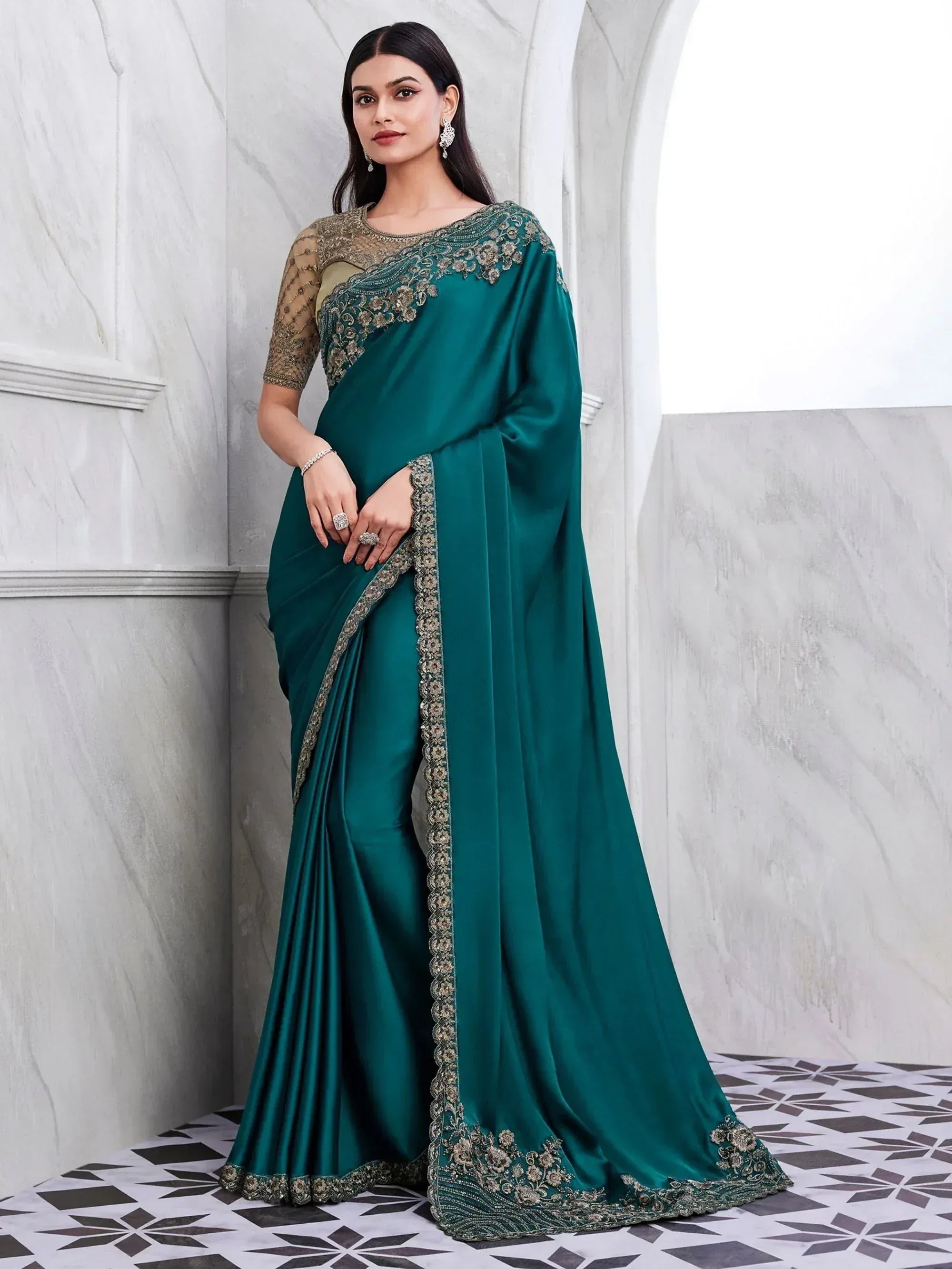 Emerald green designer saree with gold embroidery and sheer blouse, perfect for Indian ethnic occasions.