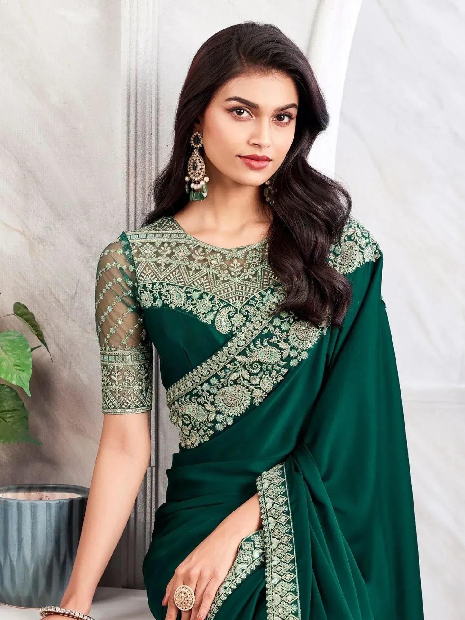 Emerald green designer saree with intricate gold embroidery and sheer sleeves, perfect for Indian ethnic occasions.