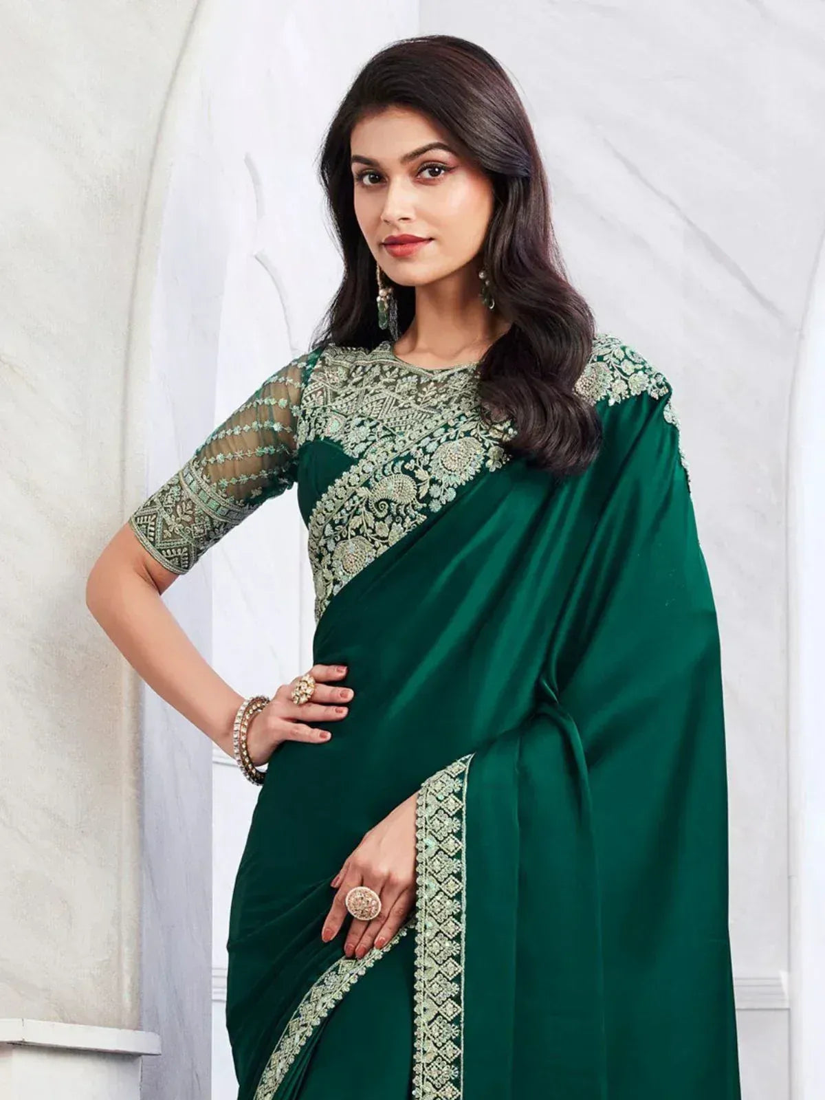 Emerald green designer saree with intricate gold embroidery and sheer sleeves, perfect for ethnic occasions.