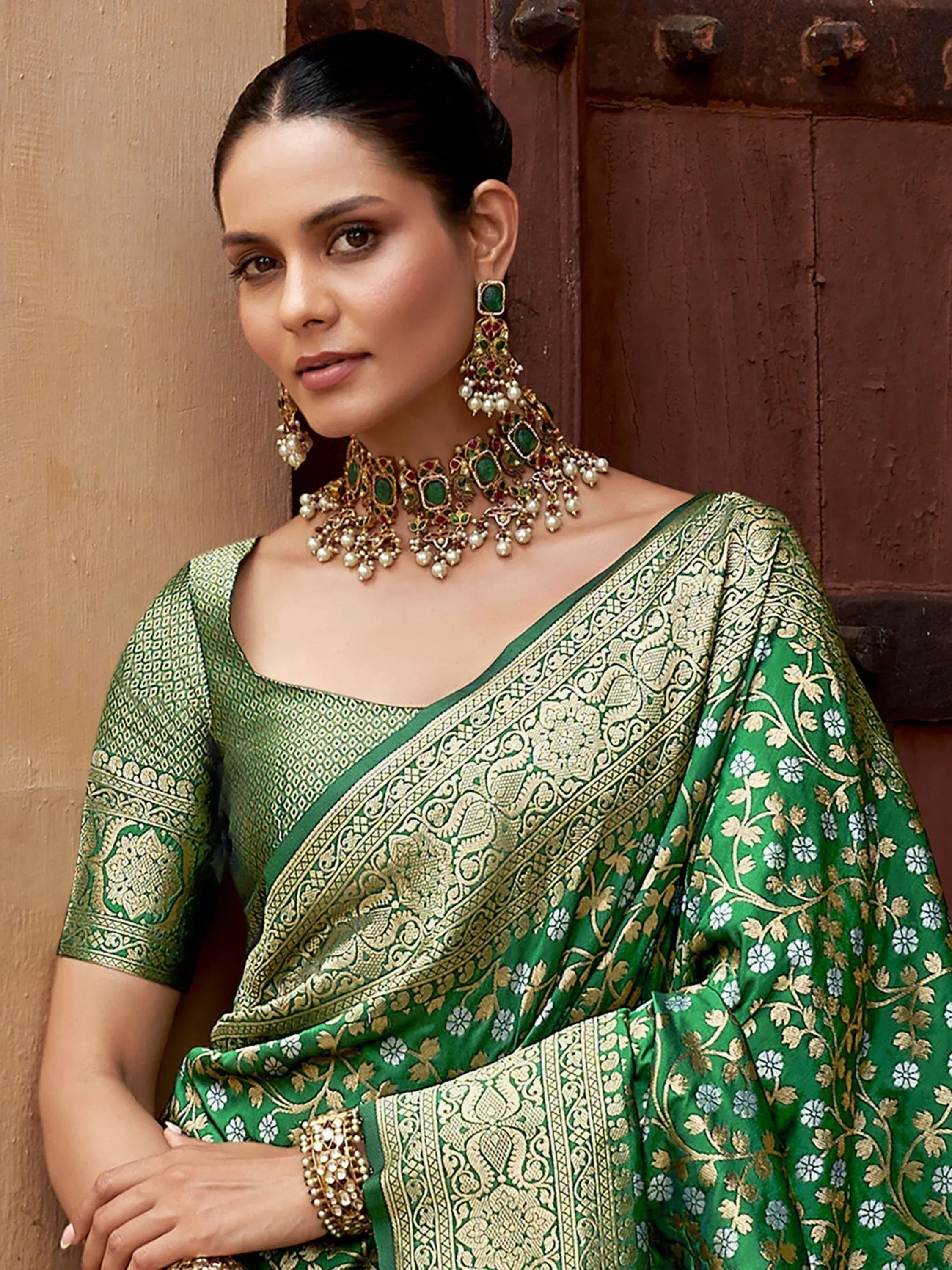 Elegant green saree with gold embroidery, paired with traditional Indian jewelry for festive occasions.