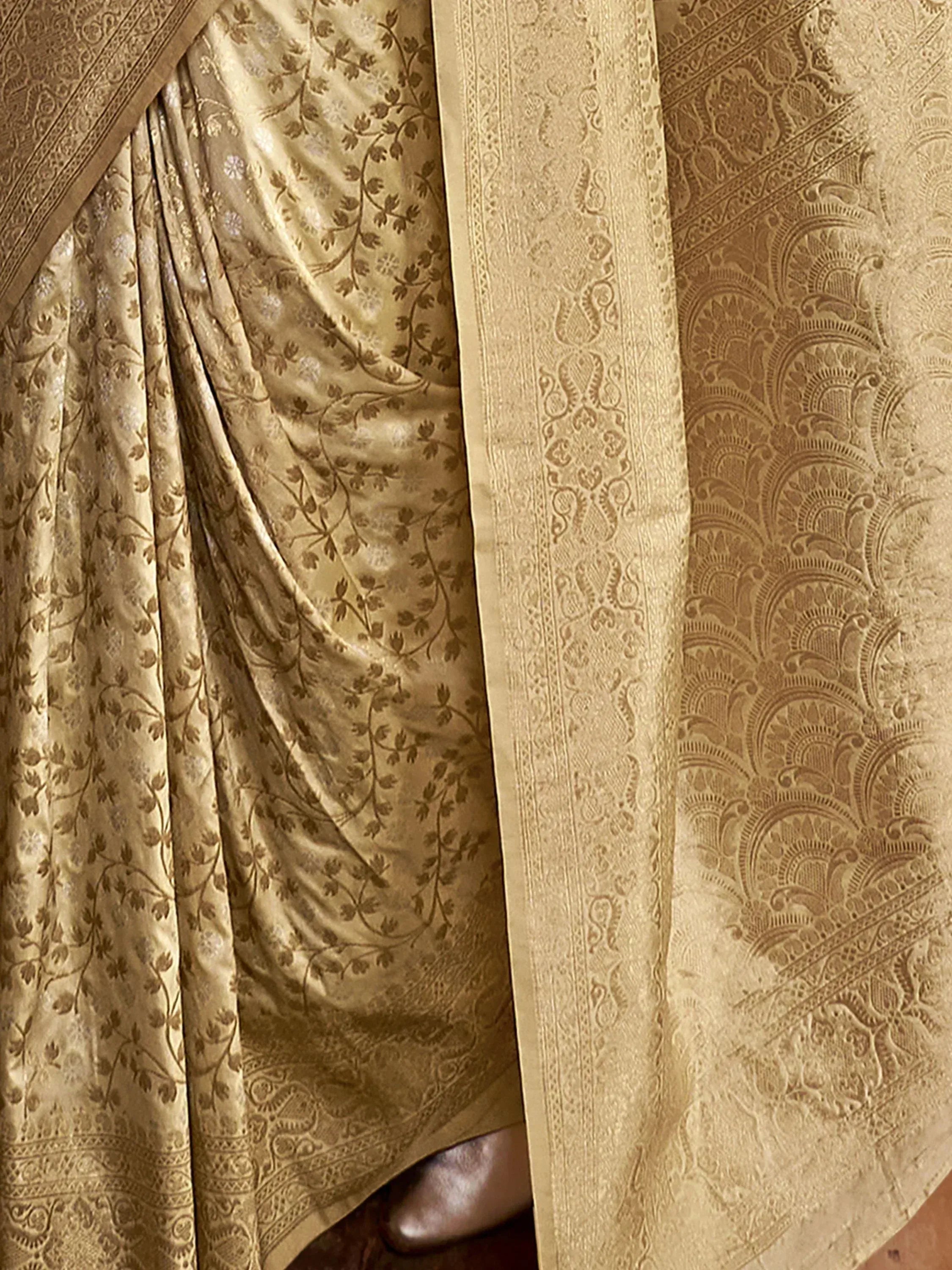 Elegant gold ethnic saree with intricate floral and paisley brocade patterns, perfect for festive occasions.