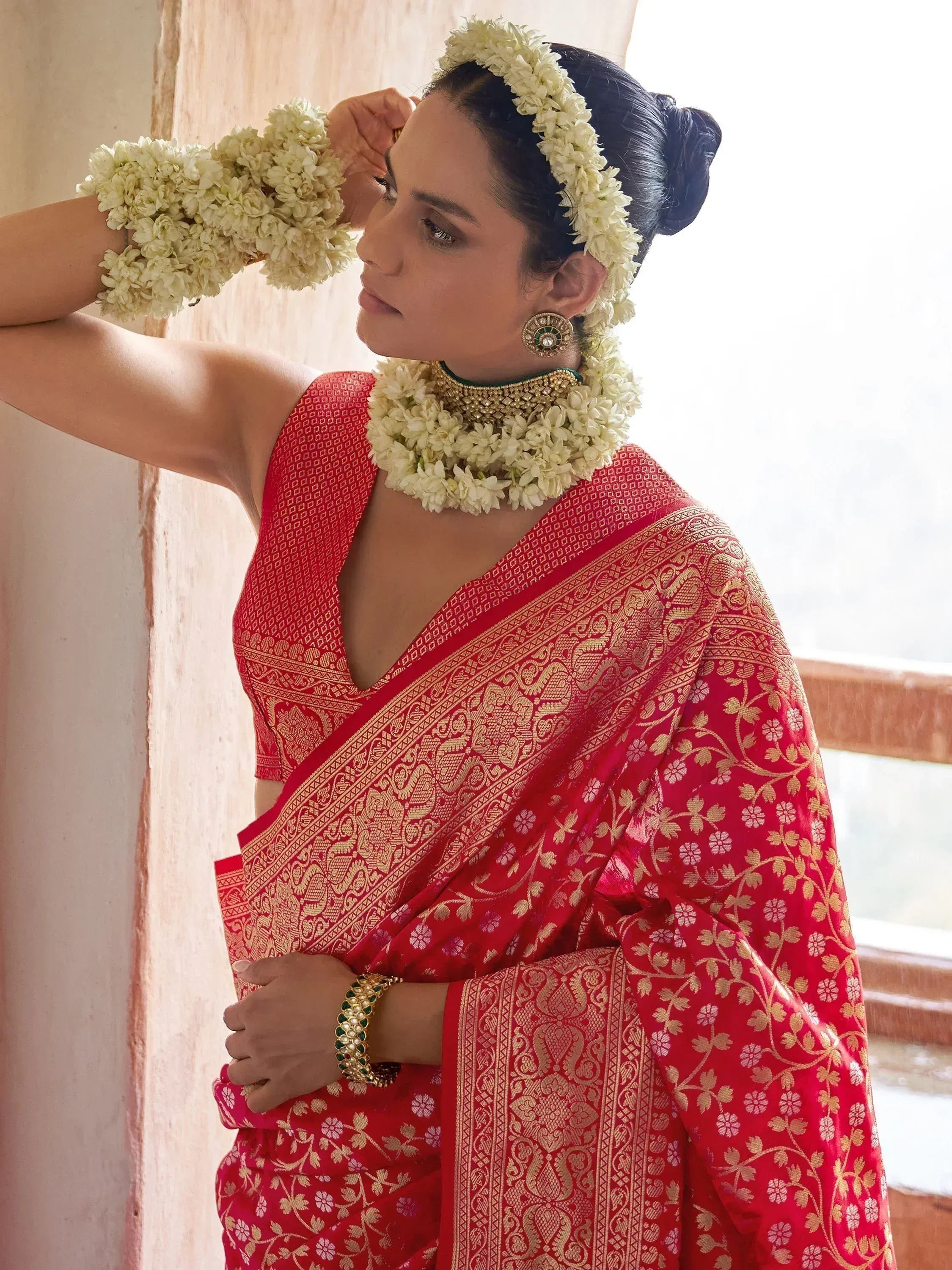 Red and gold designer saree with floral jewelry, perfect for Indian ethnic wear occasions