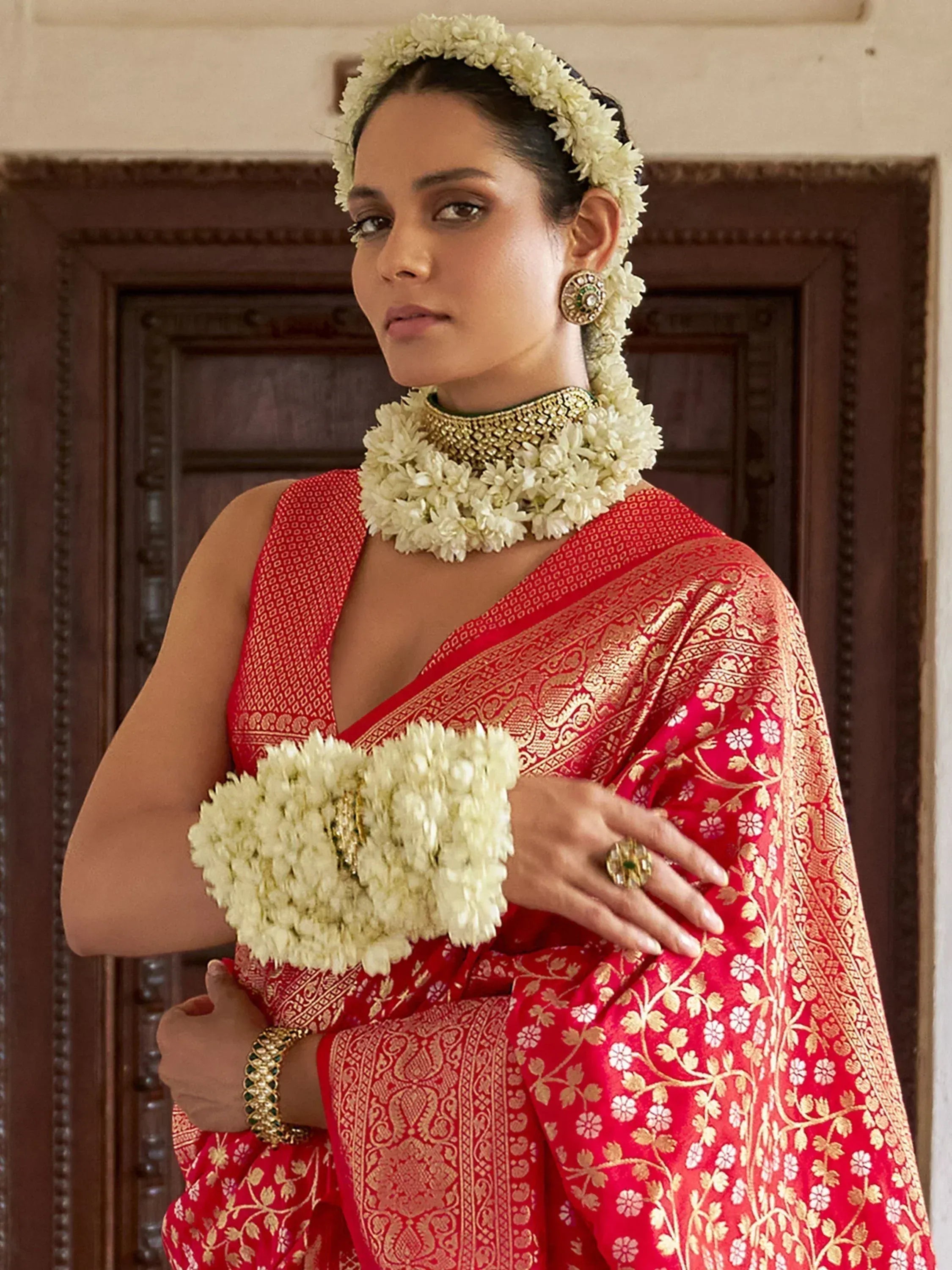 Red and gold designer saree with floral jewelry, perfect for Indian ethnic wear and weddings