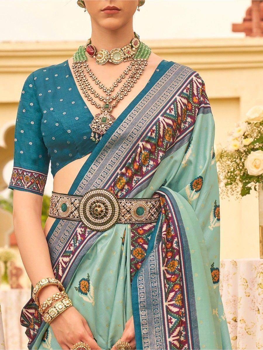 Teal and mint designer saree with embroidered border, statement belt, and traditional jewelry for ethnic wear