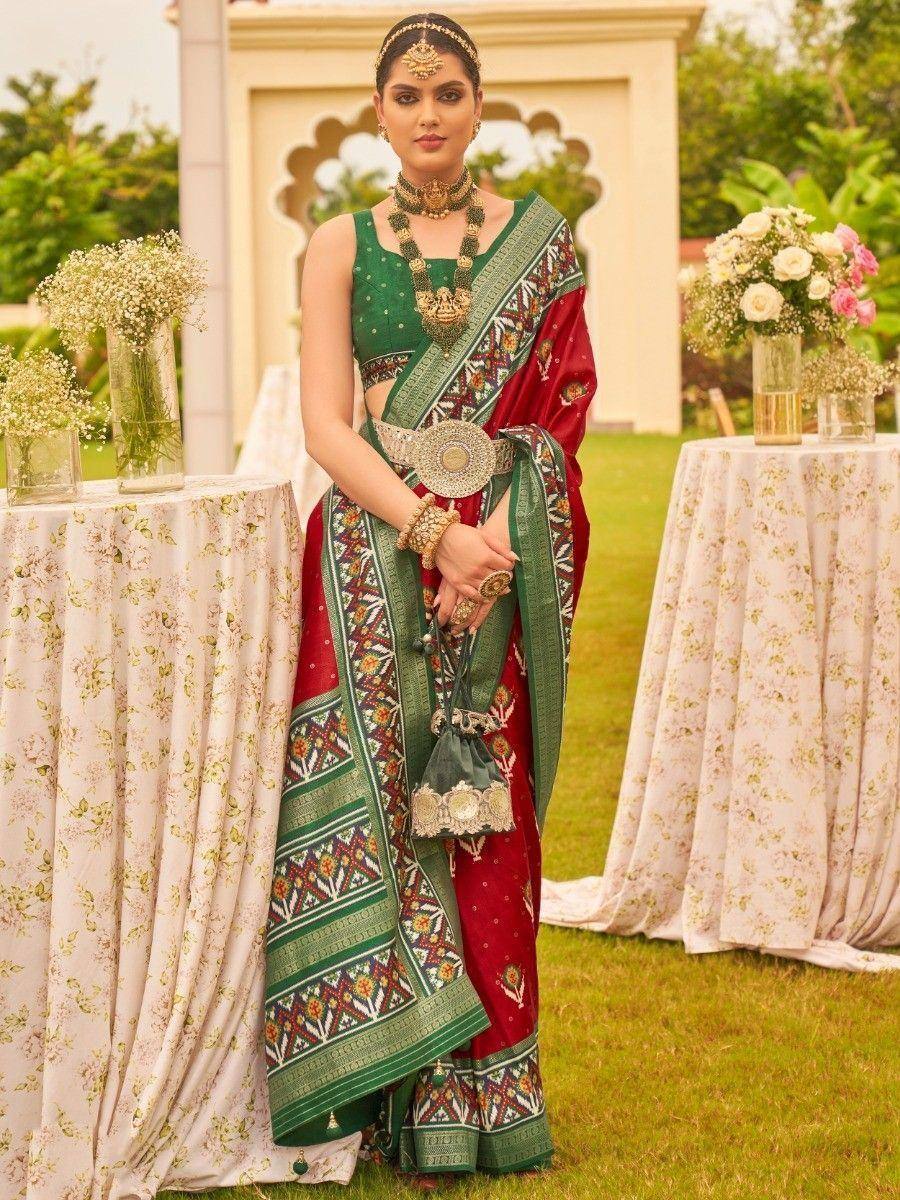 Woman in red and green embroidered saree with gold jewelry, perfect for Indian ethnic occasions