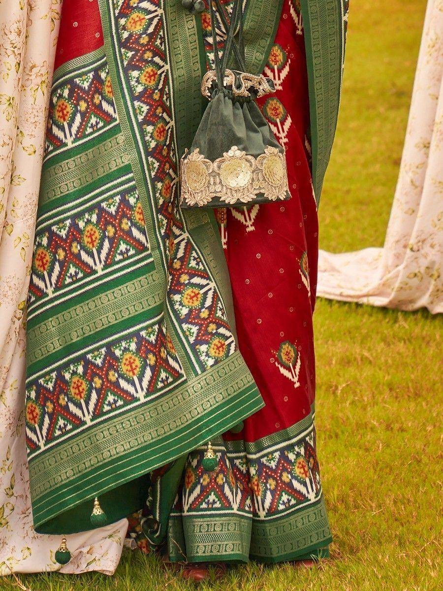 Red and green ethnic lehenga with intricate geometric patterns and embroidered border, perfect for festive occasions.