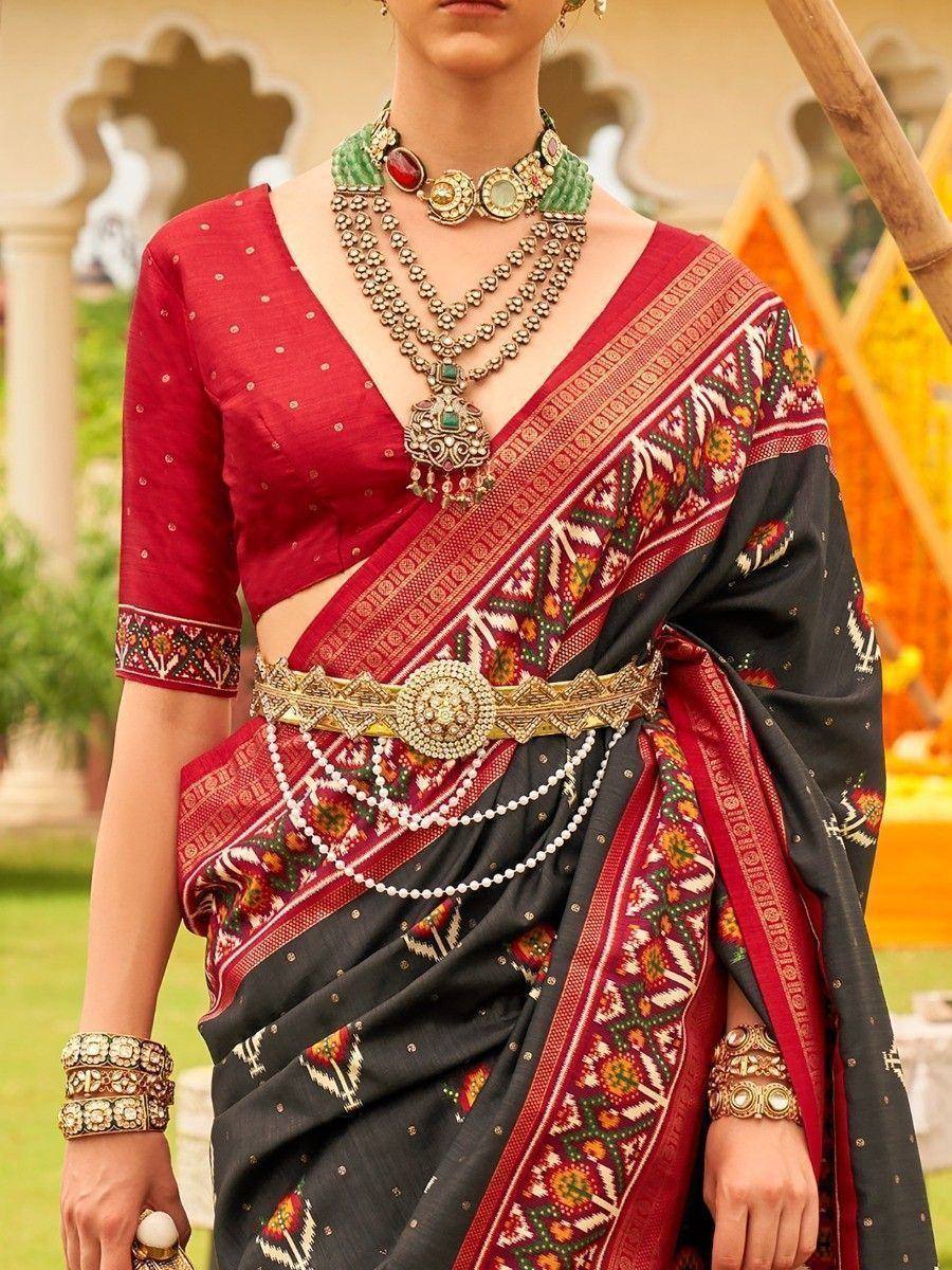 Elegant black and red ethnic saree with intricate embroidery and traditional jewelry