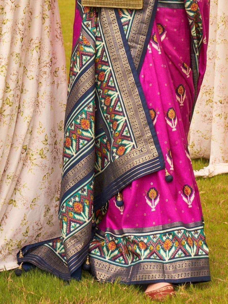 Vibrant pink ethnic saree with geometric border, floral motifs, and tassels, perfect for Indian occasions