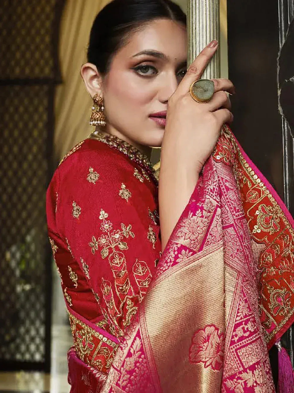 Red and pink embroidered Indian saree with gold detailing, perfect for festive occasions