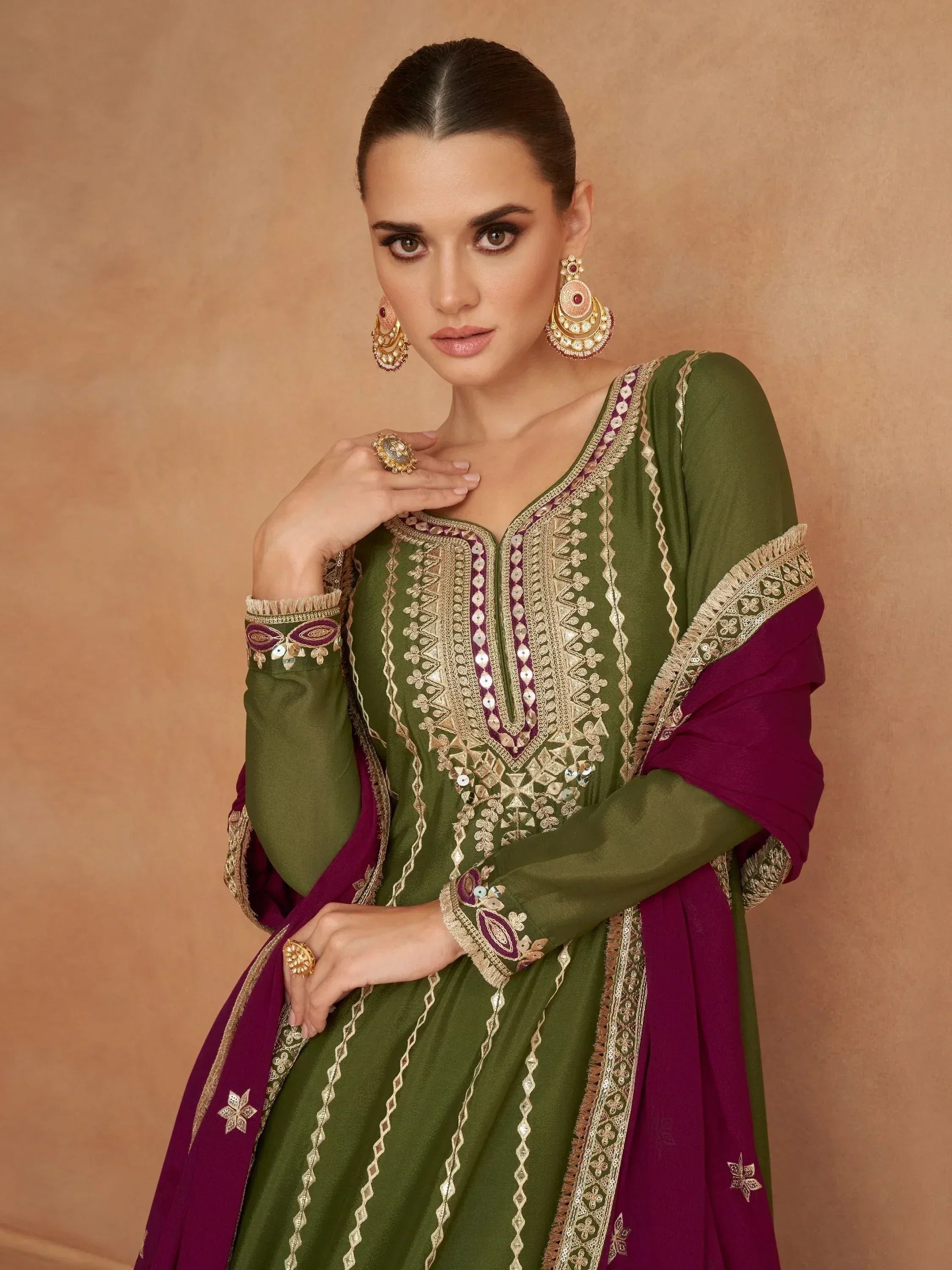 Elegant green and maroon embroidered ethnic wear with gold detailing, perfect for festive occasions.