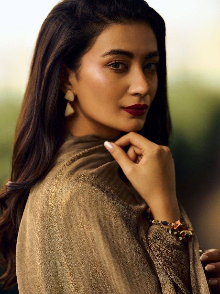 Woman in elegant ethnic wear with embroidered dupatta, showcasing designer Indian fashion