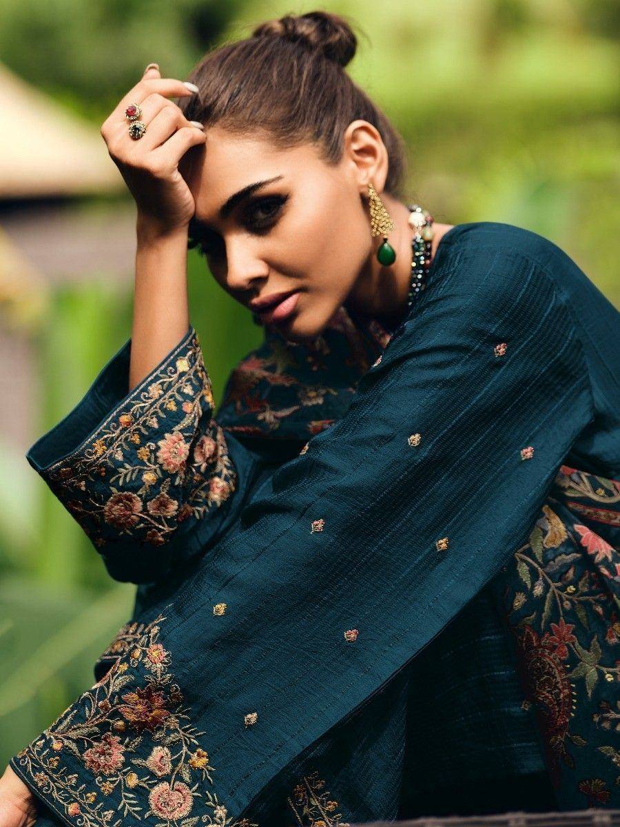 Woman in teal embroidered salwar kameez with floral sleeves, perfect for Indian ethnic wear occasions.