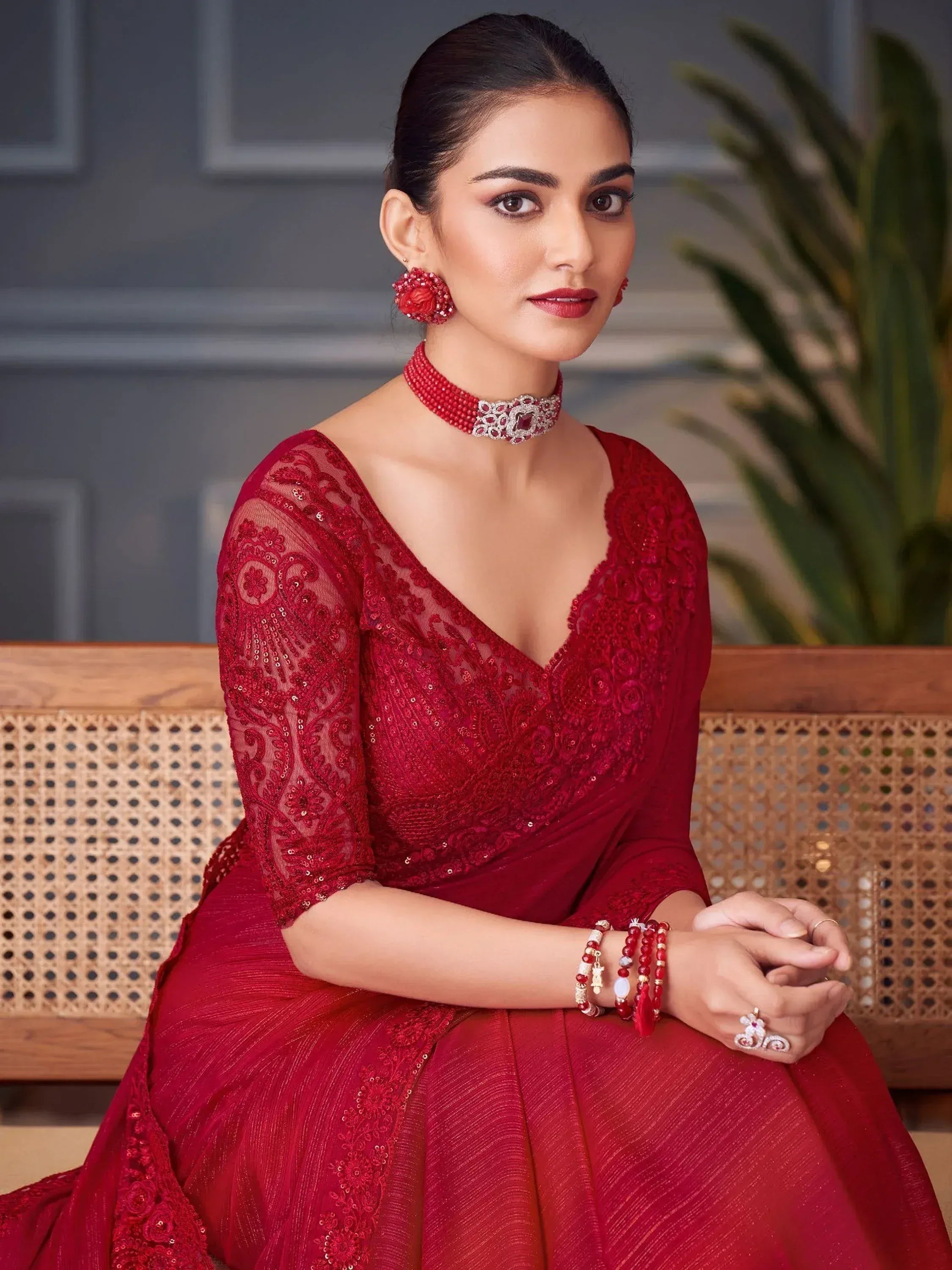 Elegant woman in red embroidered ethnic gown with matching jewelry, perfect for Indian weddings and festive occasions.