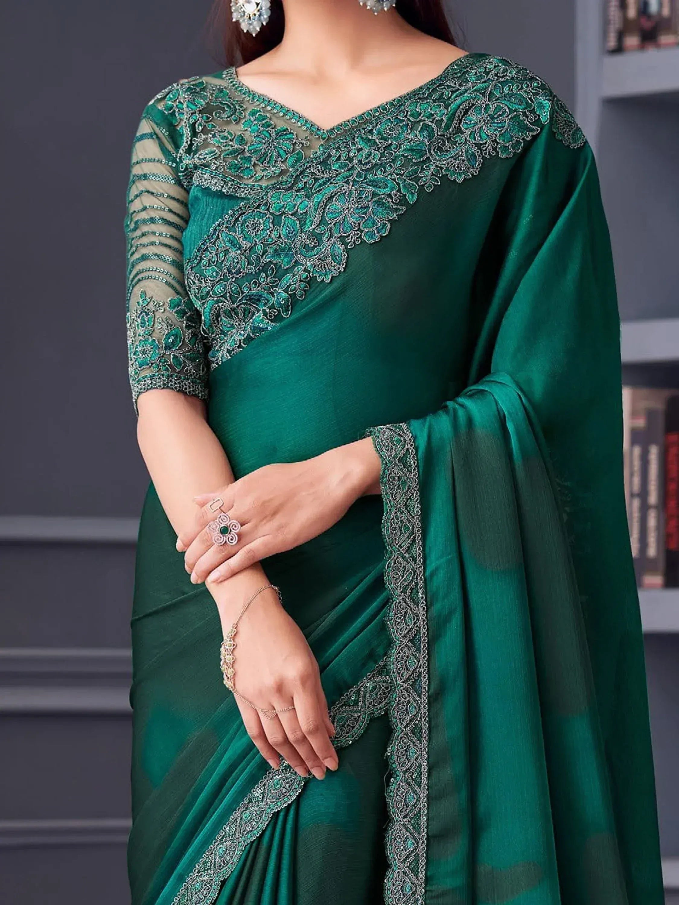 Emerald green designer saree with intricate silver embroidery and sheer sleeves, perfect for ethnic occasions.