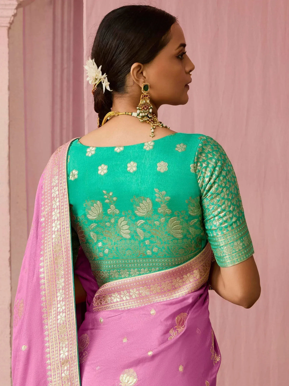 Woman in pink and green embroidered saree with gold floral motifs, traditional Indian ethnic wear