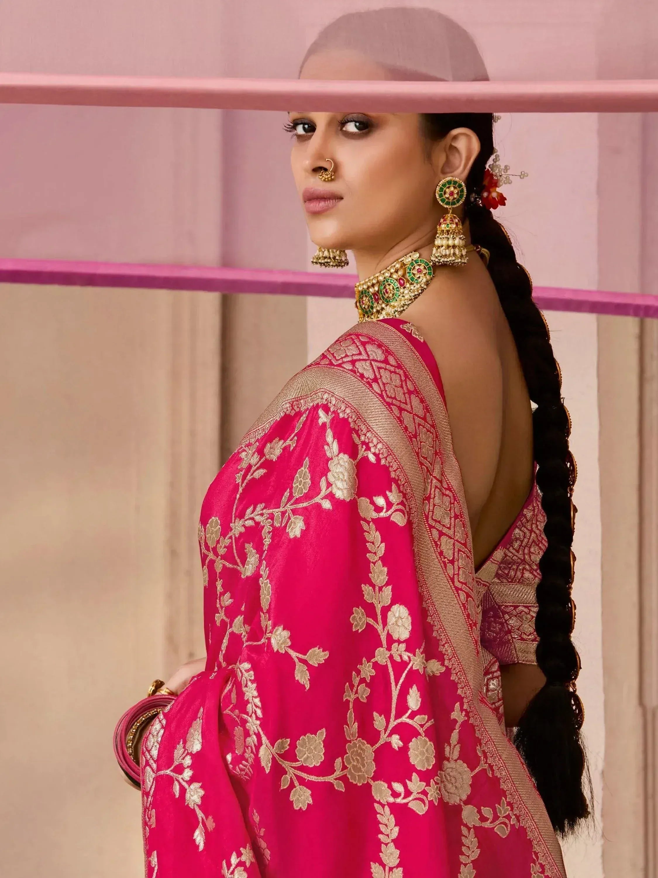 Pink embroidered saree with gold floral design, traditional Indian ethnic wear, paired with statement jewelry