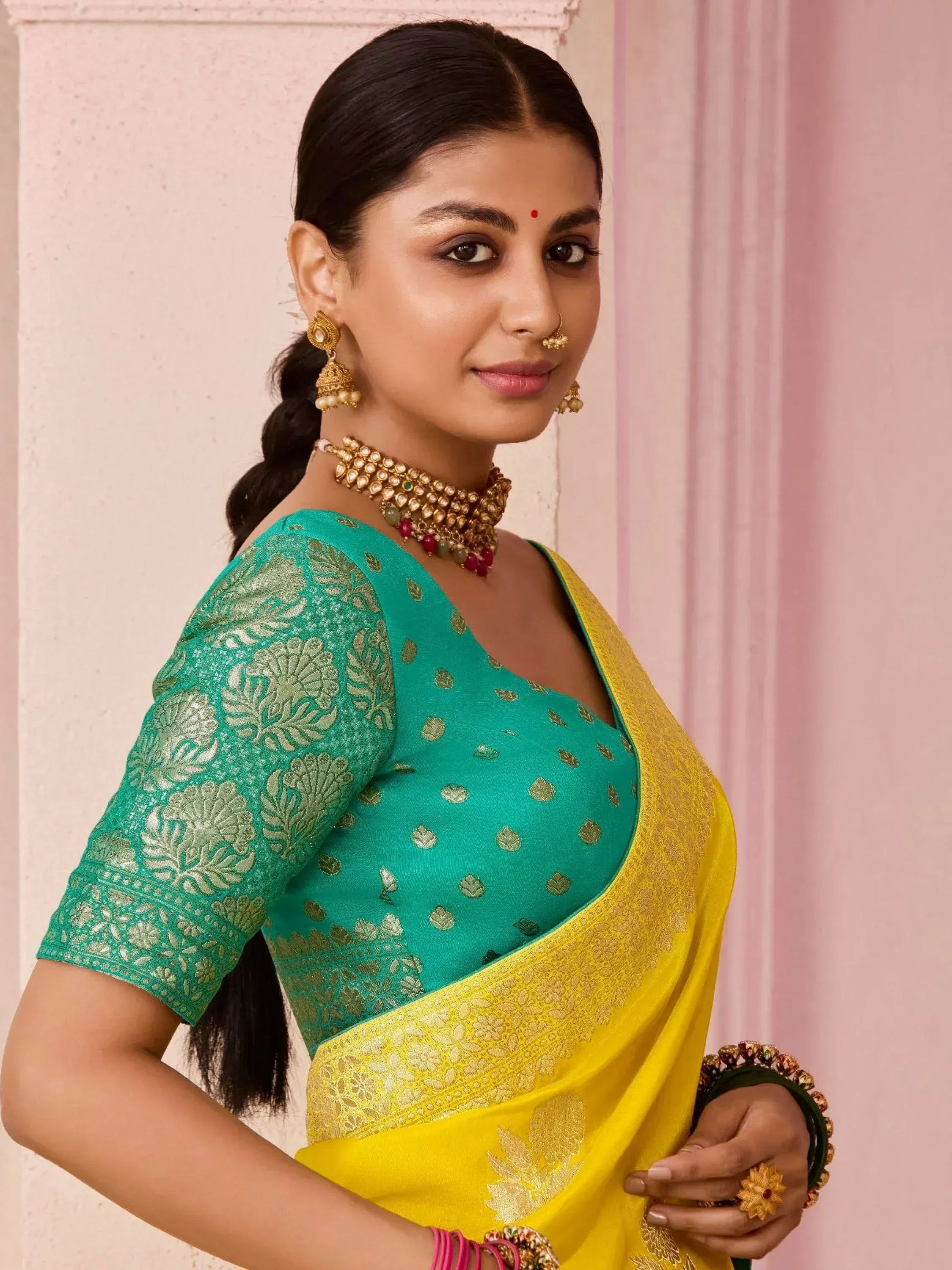 Woman in green and yellow designer saree with gold embroidery, traditional Indian ethnic wear