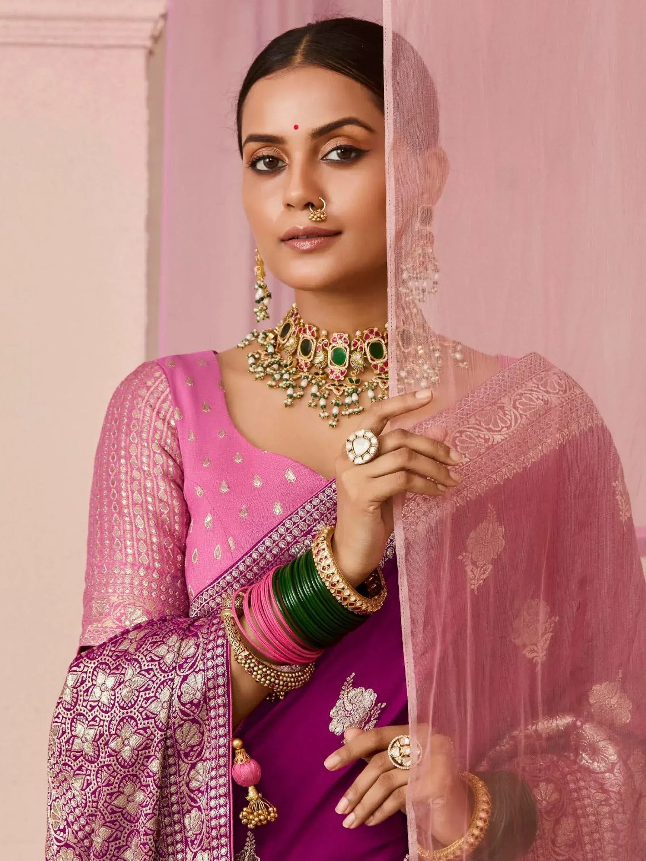 Pink and purple designer ethnic saree with gold embroidery, traditional jewelry, and sheer dupatta for Indian occasions