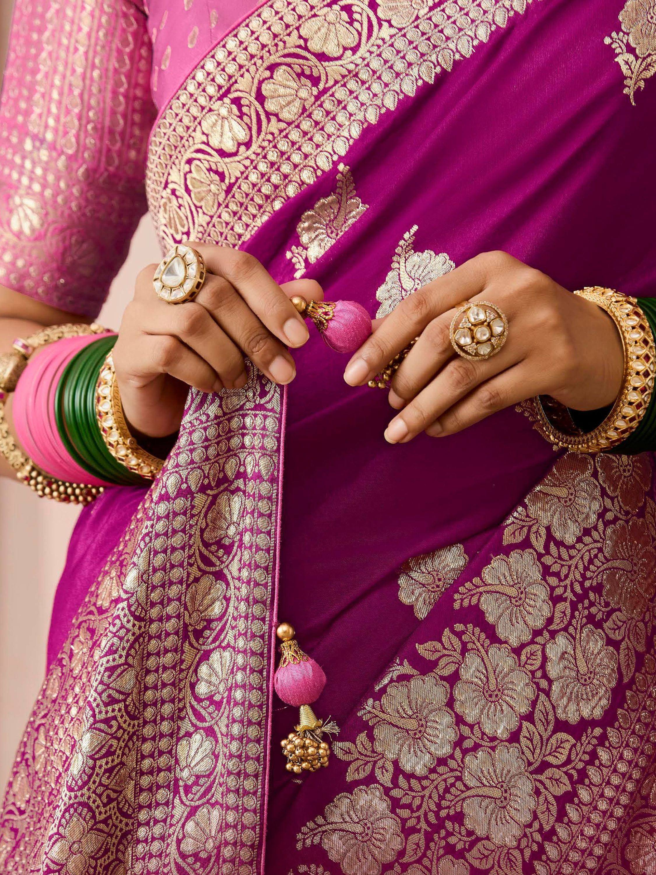 Purple and gold embroidered saree with tassels, paired with traditional Indian jewelry and bangles.