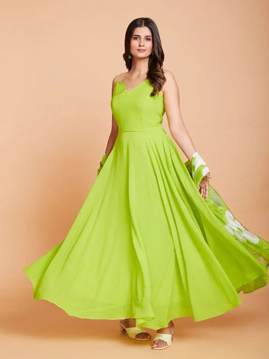 Woman in a bright green sleeveless ethnic gown with flowing skirt and dupatta