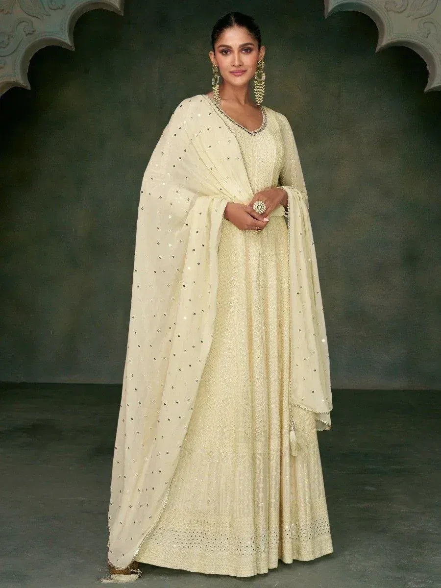 Elegant cream ethnic gown with sequin detailing and matching dupatta, perfect for Indian weddings or festive occasions.