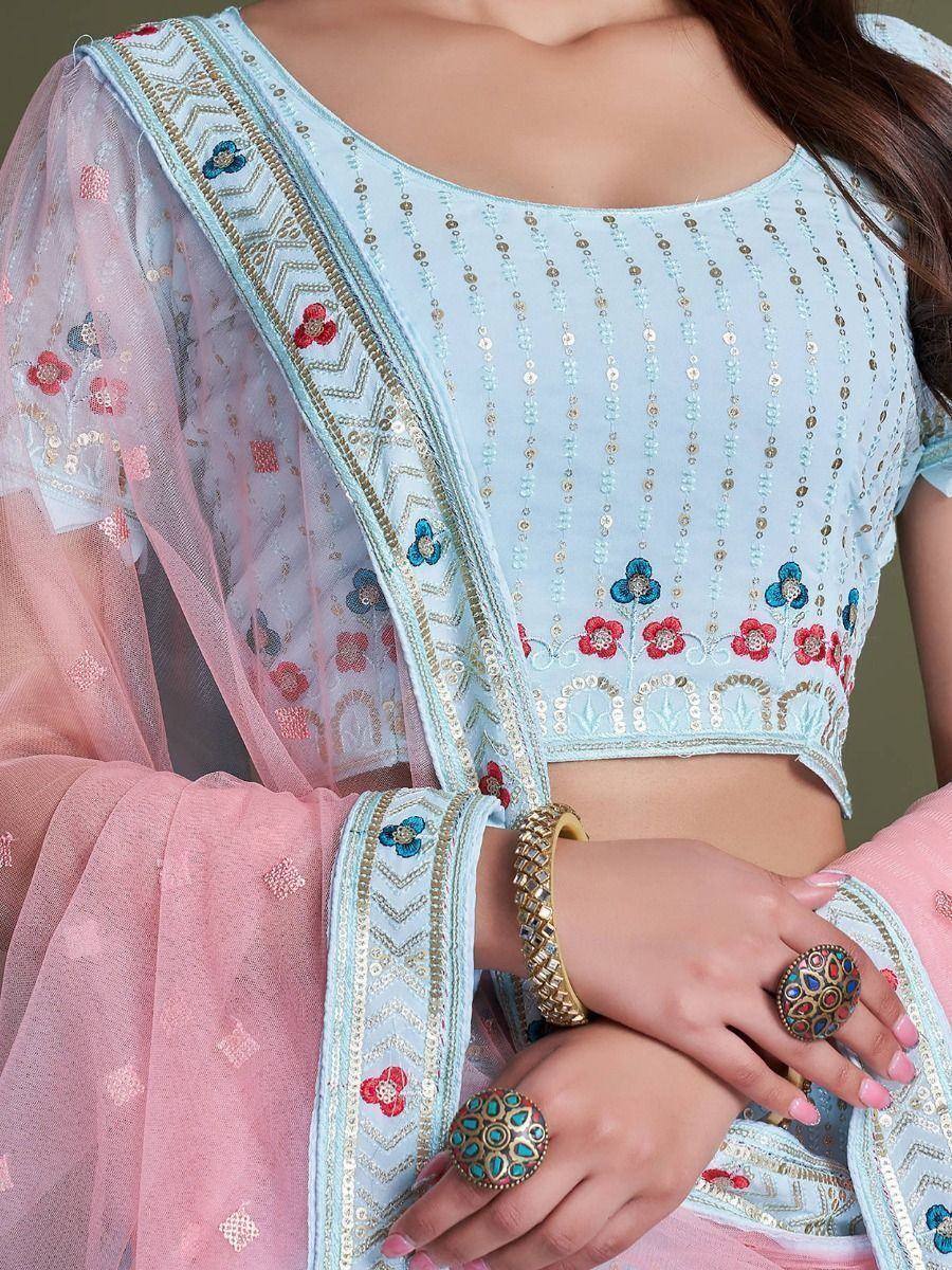 Light blue embroidered crop top with floral motifs, paired with pink sheer dupatta, perfect for ethnic wear.
