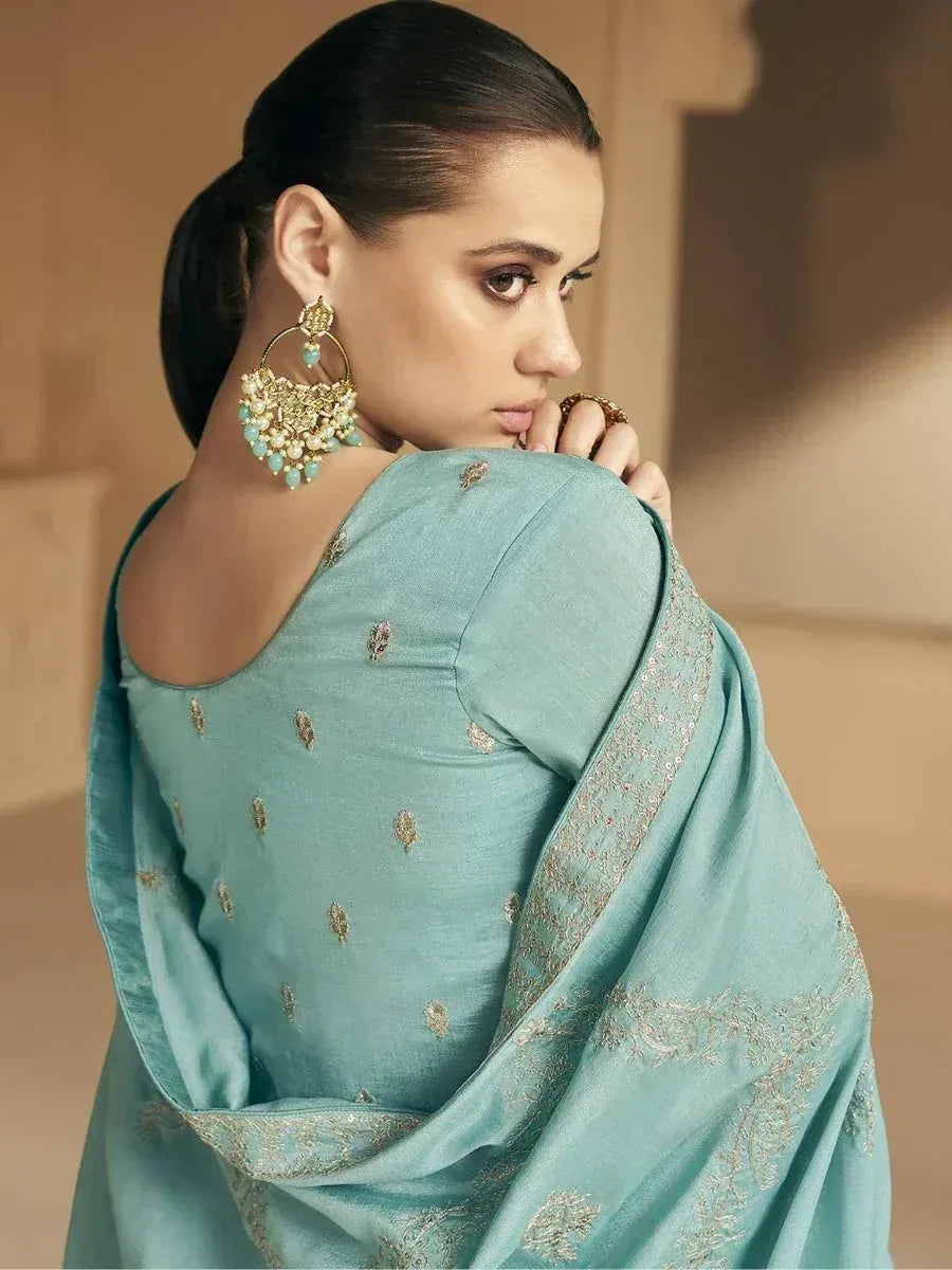 Elegant teal saree with gold embroidery, paired with statement earrings for Indian ethnic wear.