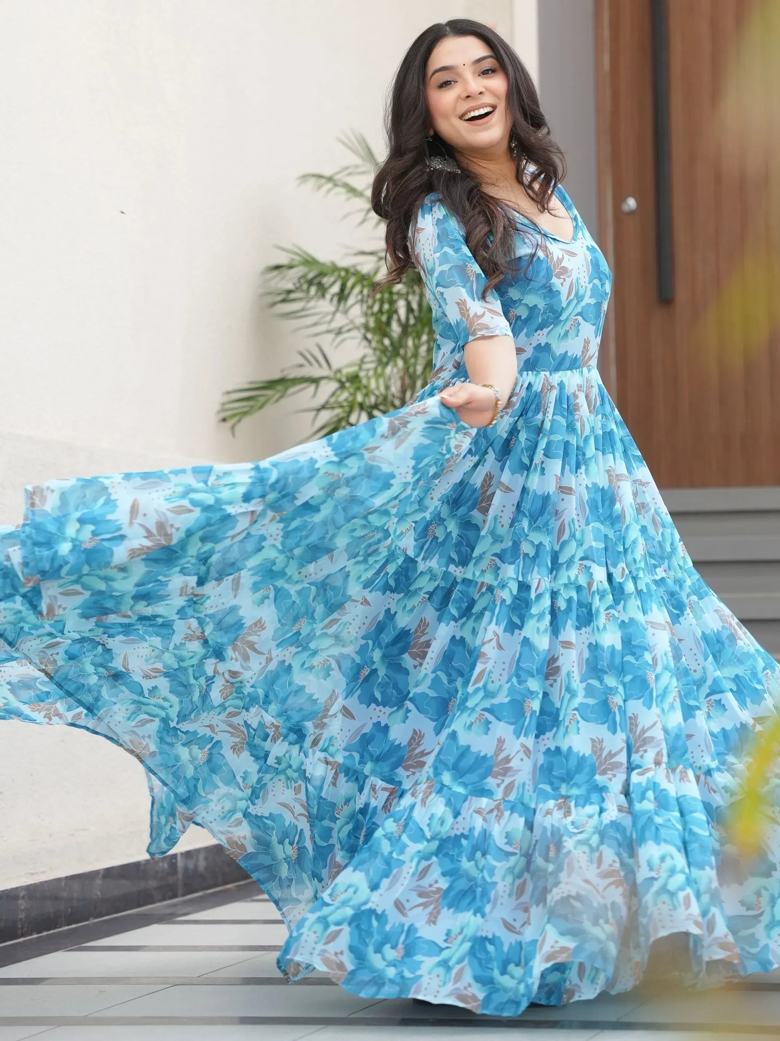 Woman twirling in blue floral ethnic gown, perfect for festive occasions and Indian wear