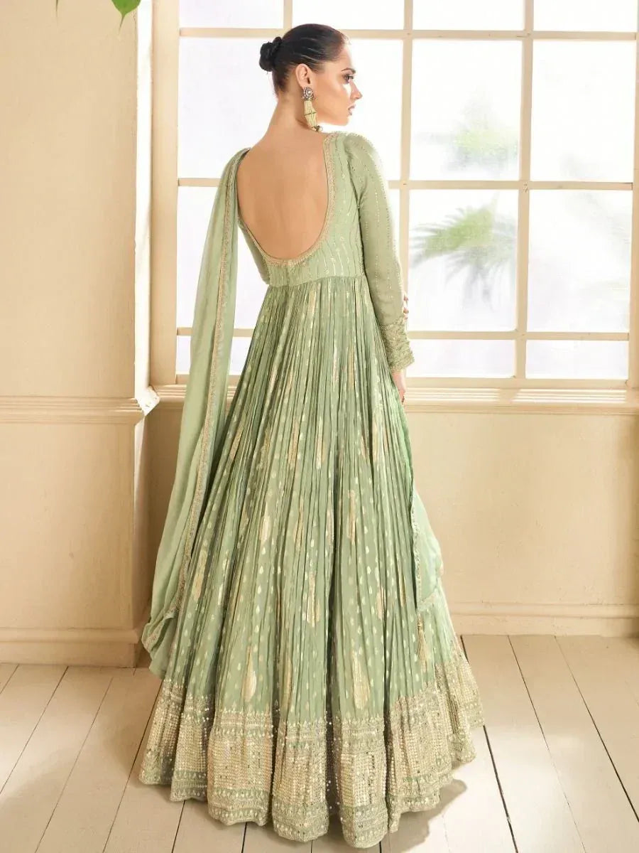 Elegant sage green anarkali gown with gold embroidery, open back, and pleated skirt for Indian ethnic wear