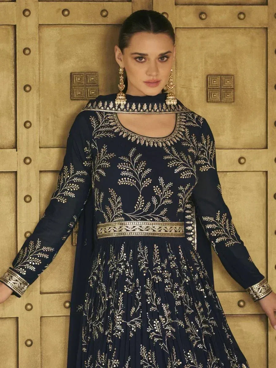 Navy blue embroidered ethnic gown with gold floral detailing, perfect for Indian festive occasions.