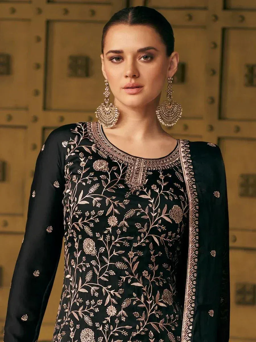 Black embroidered ethnic kurti with gold floral detailing, paired with statement earrings for festive wear