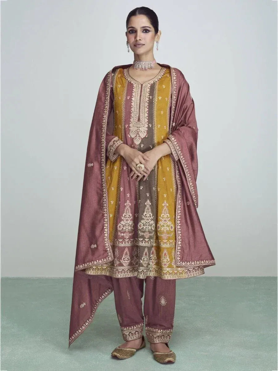 Elegant Indian salwar kameez with gold embroidery, maroon dupatta, and traditional jewelry for festive occasions