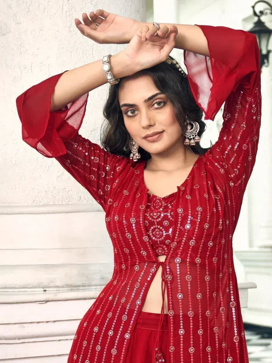 Woman in a red embroidered ethnic gown with flared sleeves and silver jewelry
