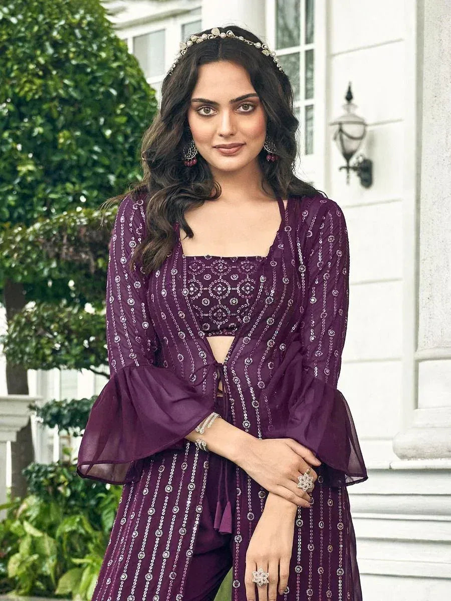 Woman in a purple embellished ethnic gown suit with flared sleeves, posing outdoors