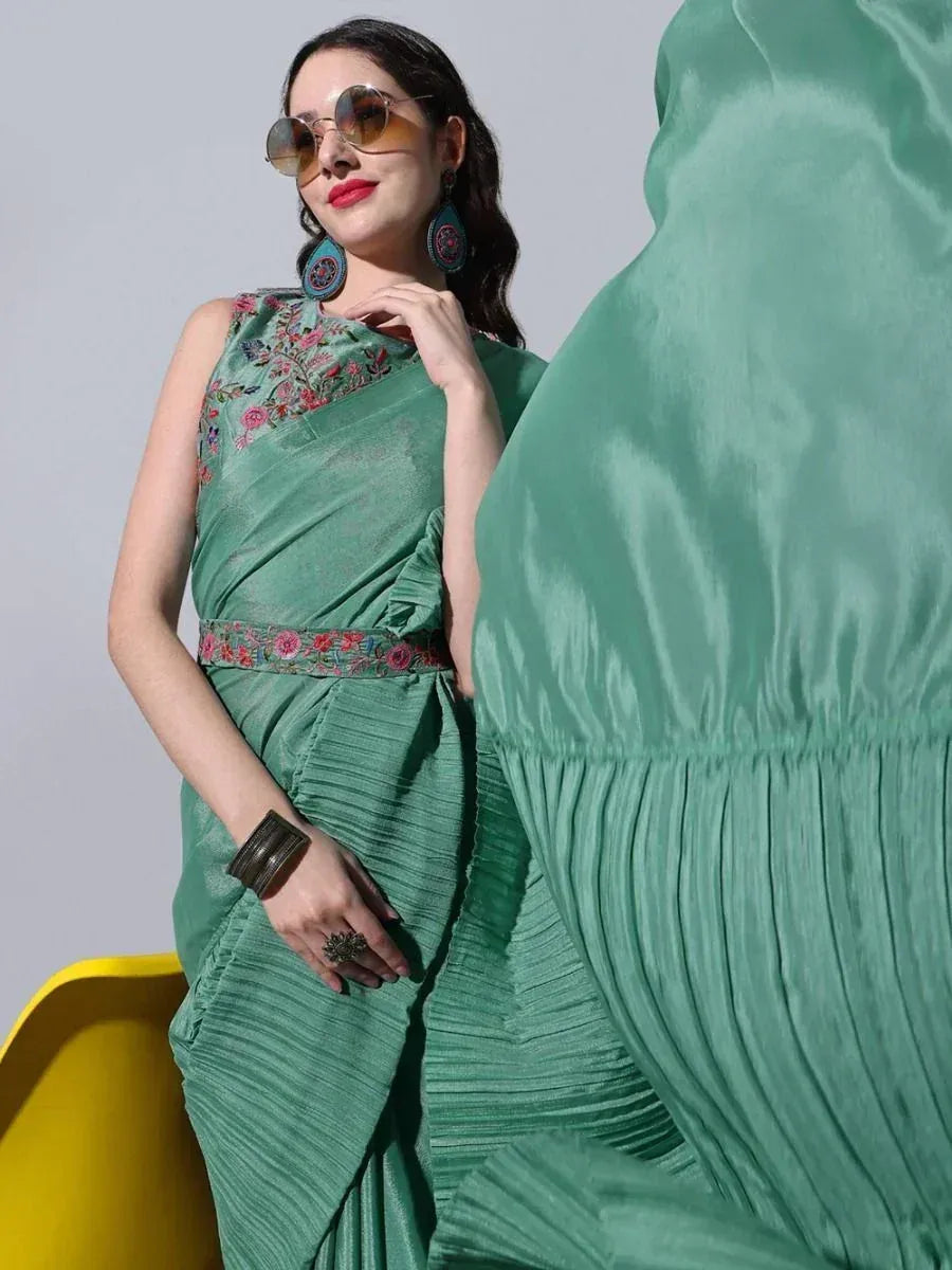 Woman in green embroidered saree with floral belt, stylish ethnic wear for women