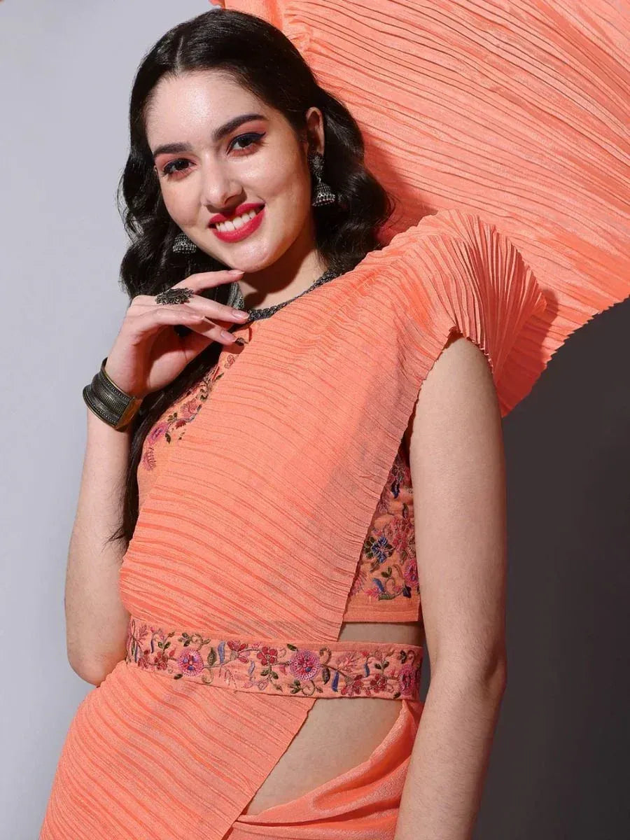 Woman in peach pleated saree with floral embroidery, ethnic Indian wear