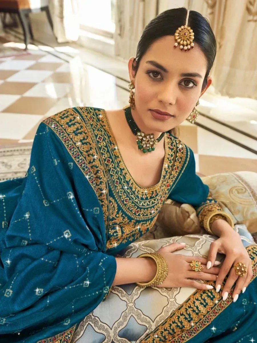 Elegant teal ethnic gown with gold embroidery, paired with traditional jewelry for festive occasions