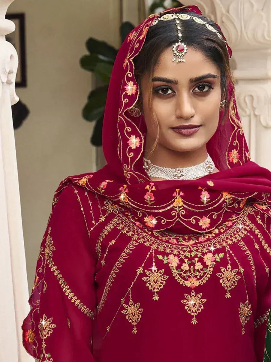 Woman in maroon embroidered ethnic salwar kameez with matching dupatta and jewelry