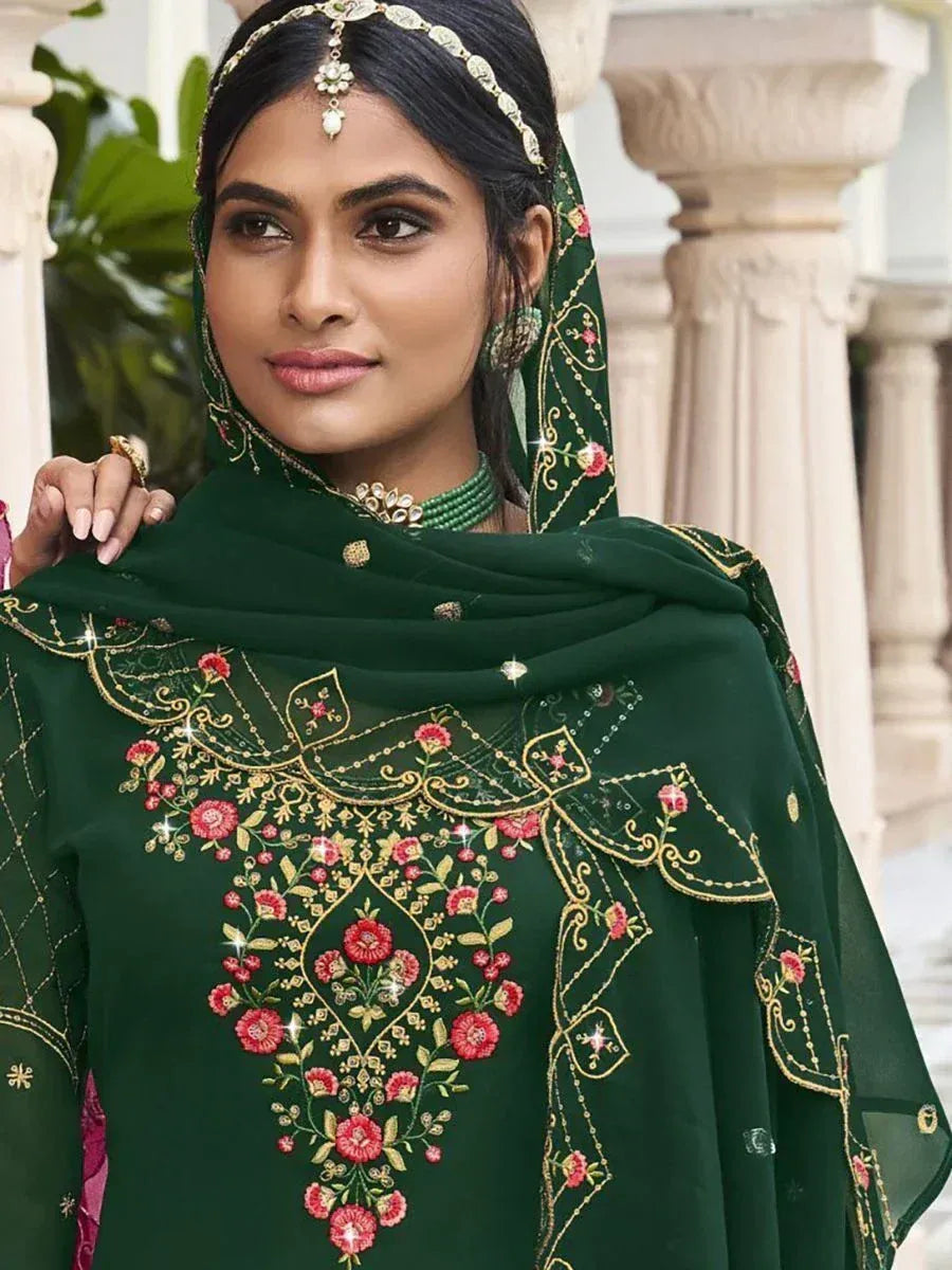 Woman in green embroidered ethnic salwar kameez with floral gold detailing and matching dupatta
