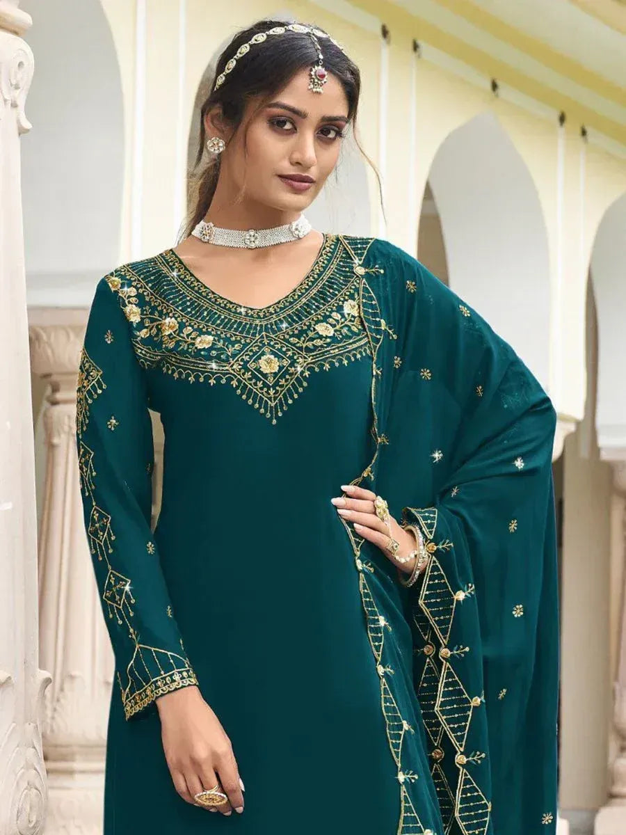 Woman in teal embroidered salwar kameez with gold detailing and matching dupatta