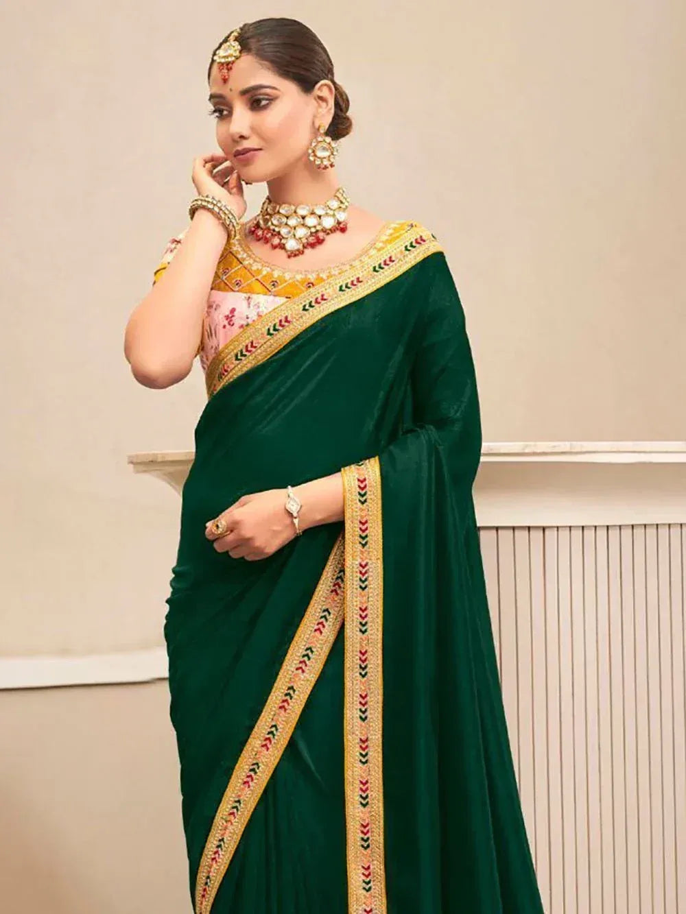 Emerald green velvet saree with gold embroidery, paired with floral blouse and traditional jewelry