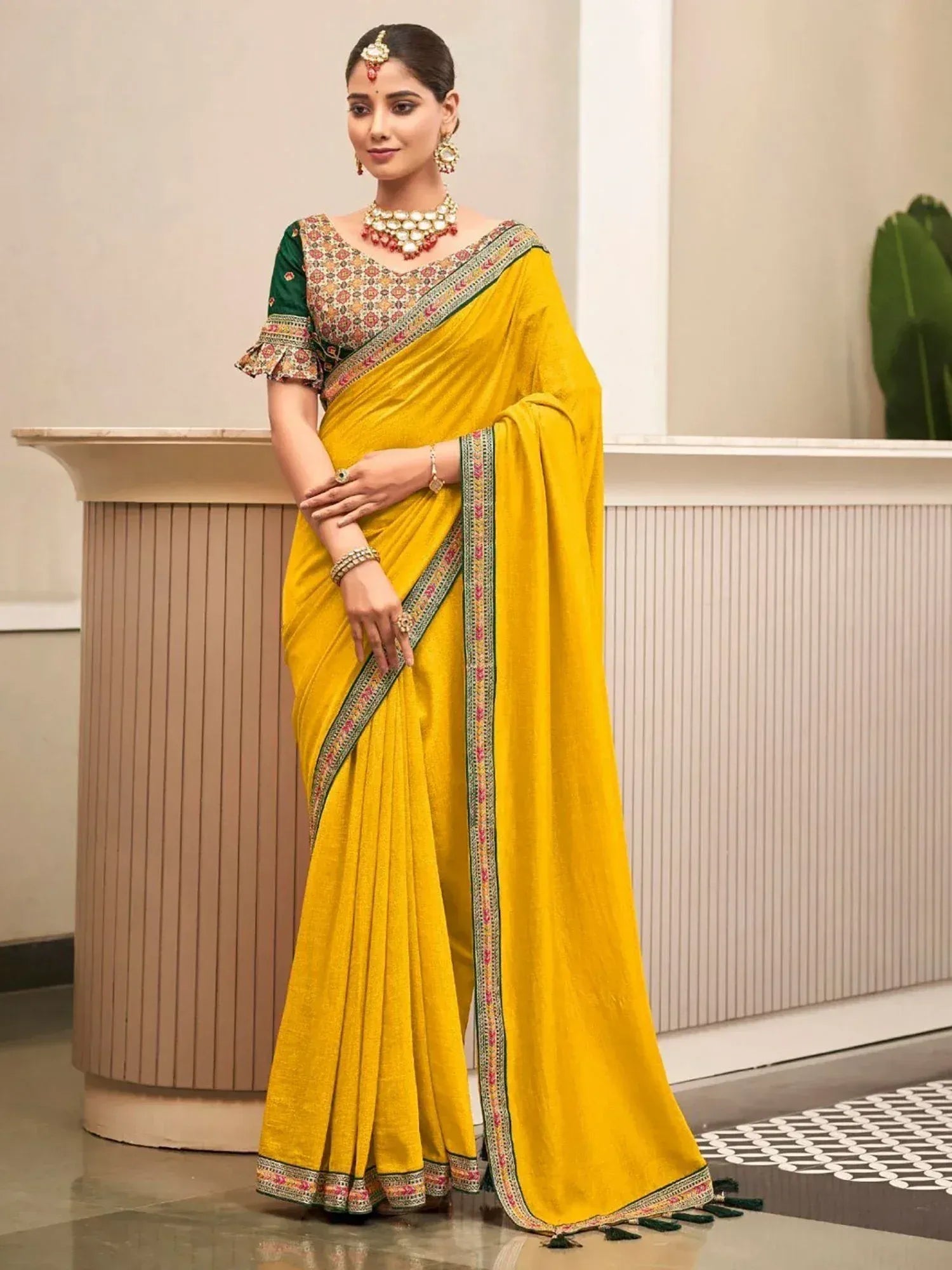 Yellow ethnic saree with green border and embroidered blouse, perfect for Indian occasions