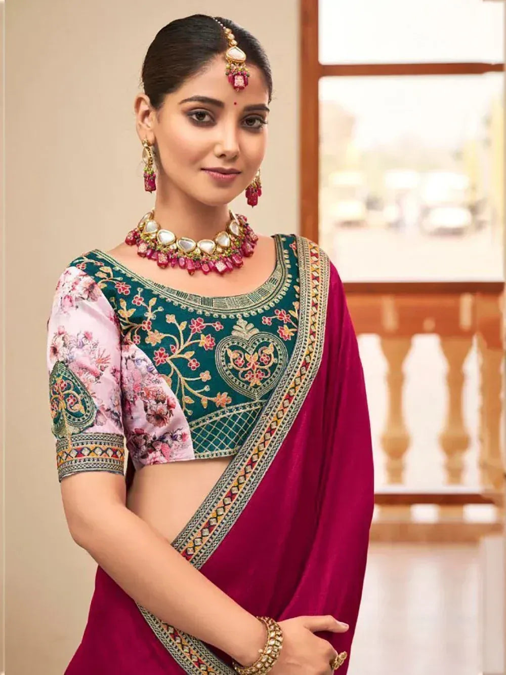 Woman in designer ethnic saree with floral blouse, traditional jewelry, and embroidered details