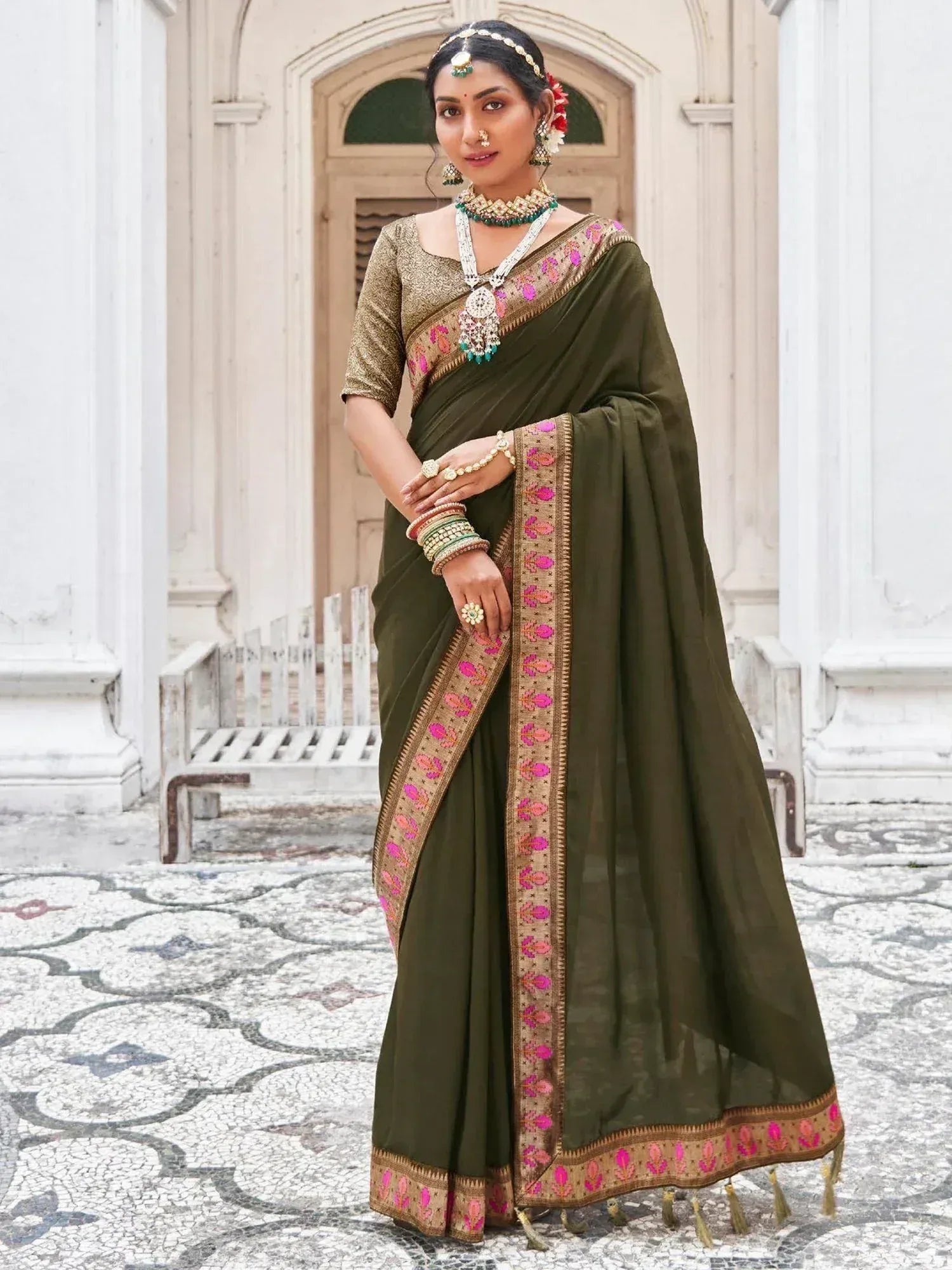 Olive green ethnic saree with pink and gold border, paired with designer blouse and traditional jewelry