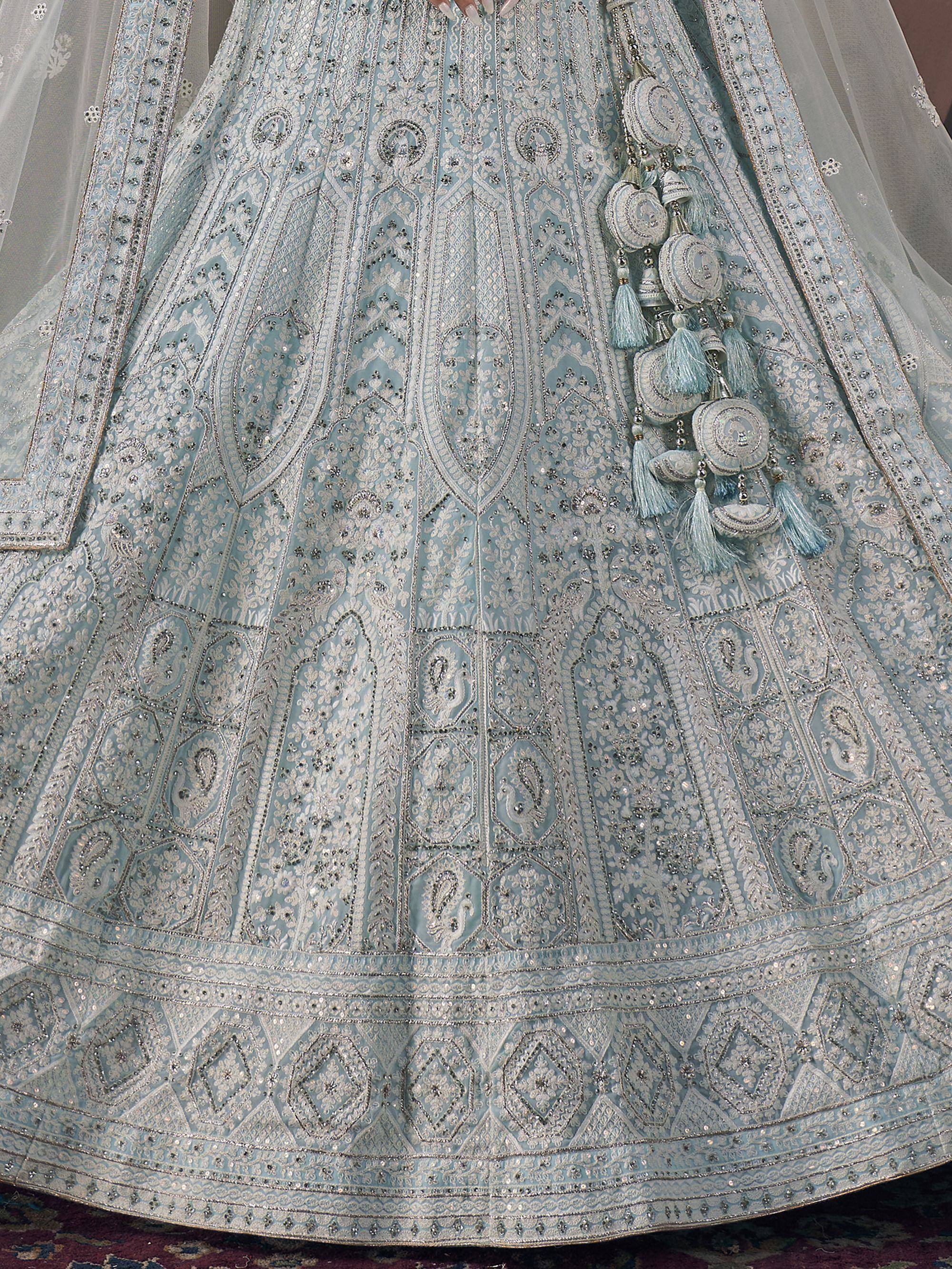 Light blue designer lehenga with intricate silver embroidery and tassel details, perfect for weddings and festive occasions.