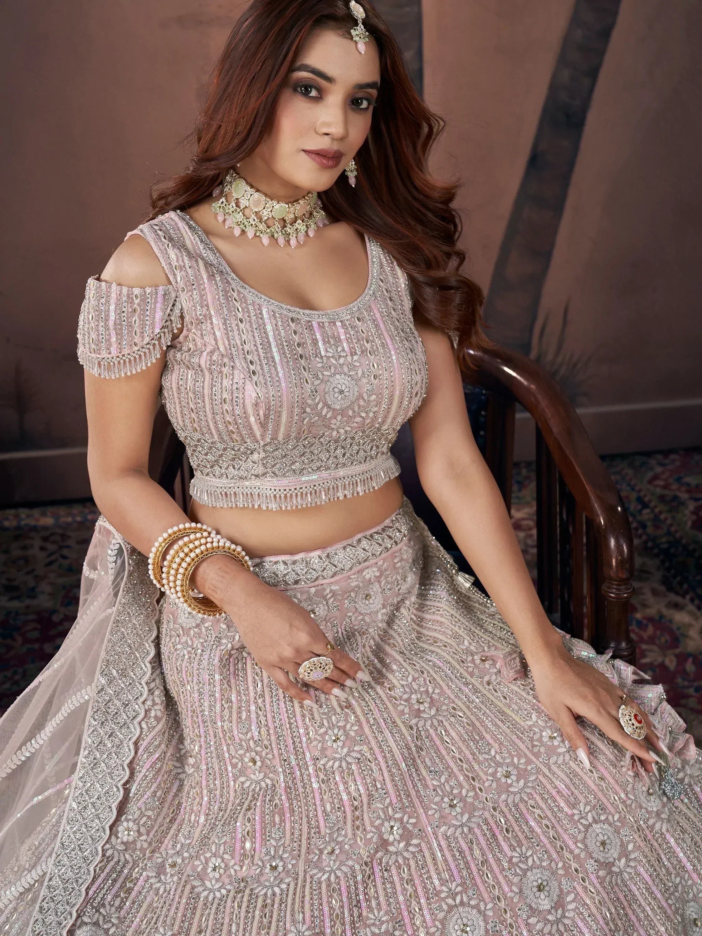 Elegant pink designer lehenga choli with intricate embroidery and sequin work, perfect for Indian weddings.