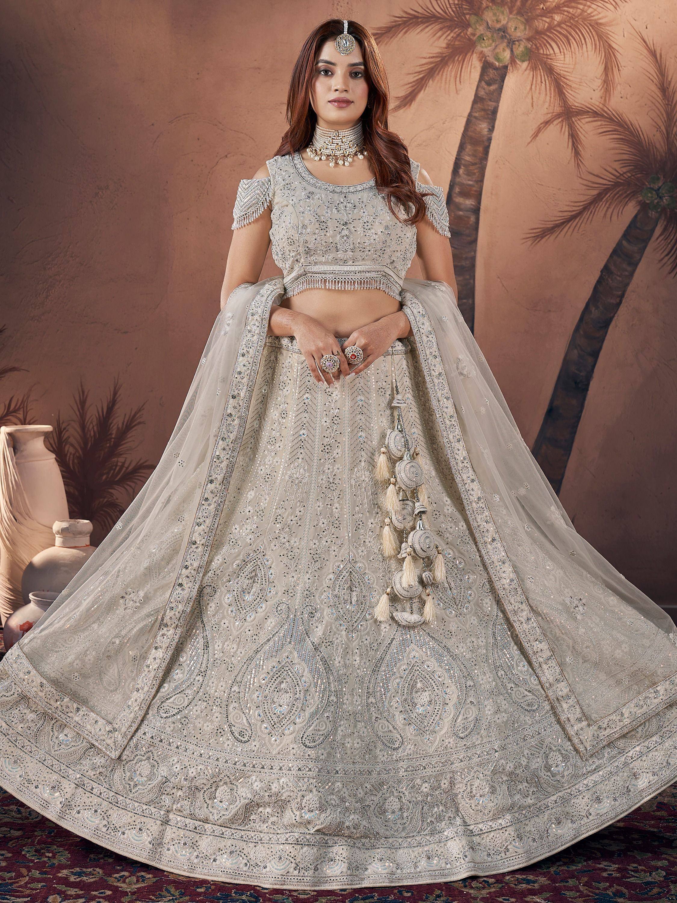 Elegant ivory lehenga choli with heavy embroidery, tassels, and off-shoulder blouse for Indian weddings