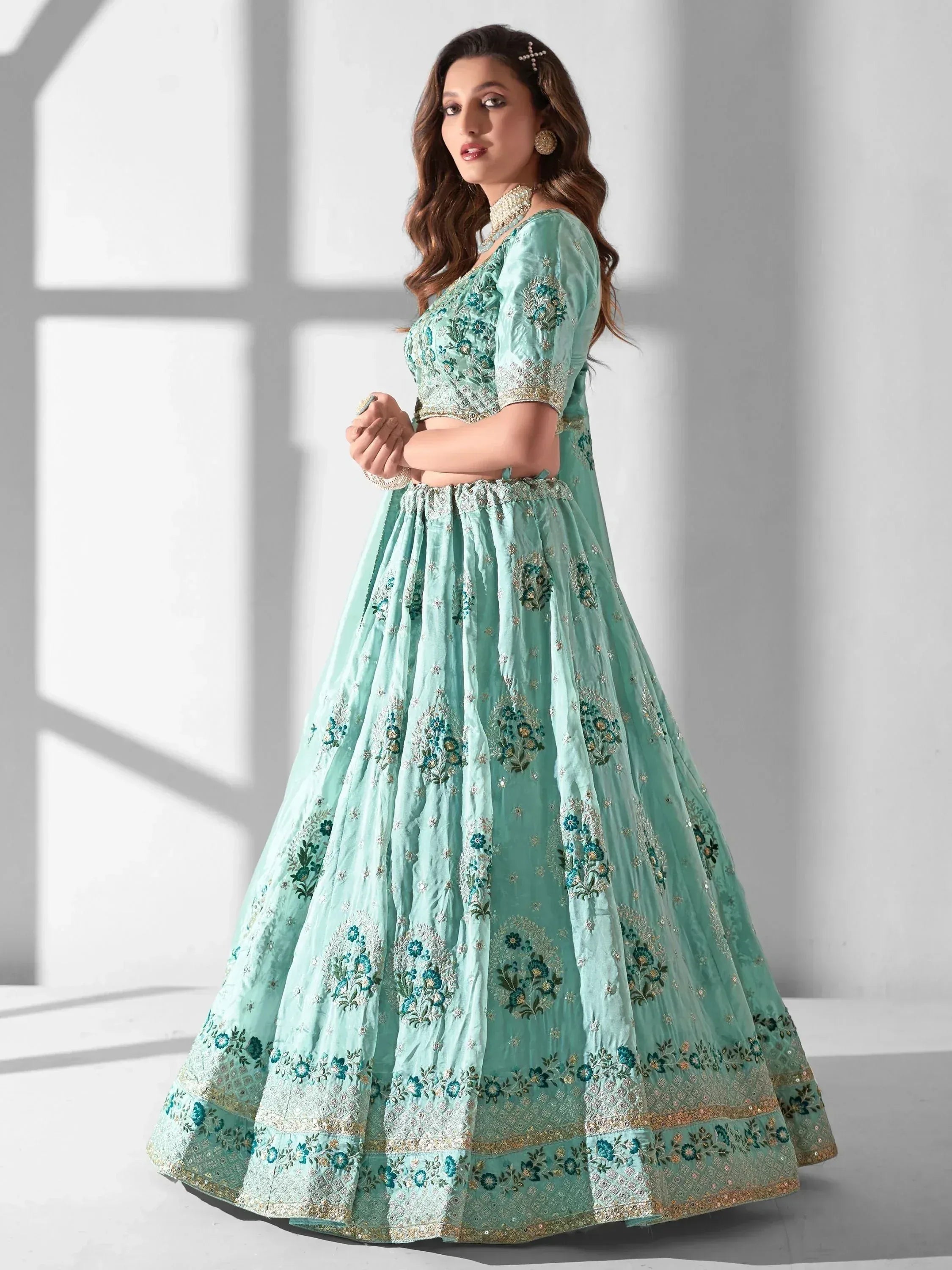 Mint green designer lehenga choli with floral embroidery and gold detailing for Indian ethnic wear
